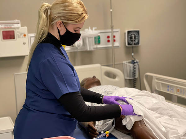 nursing student learning on a mannequin